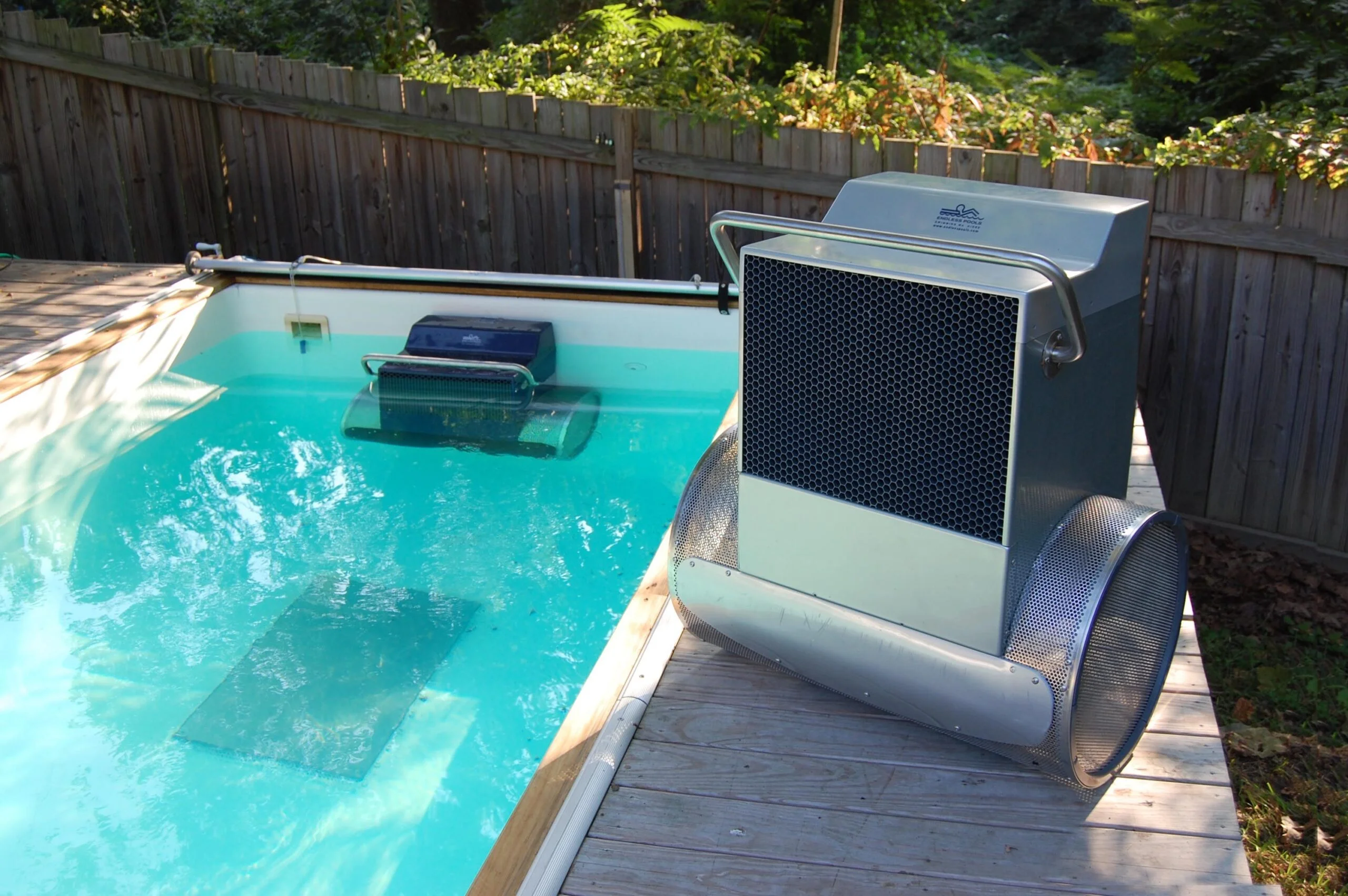 Gray and silver Endless Pools Fastlane swim current machine, placed poolside.