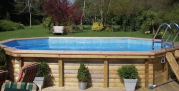 Wooden above ground pool with ladder, surrounded by wood paneling, ready for swimming.