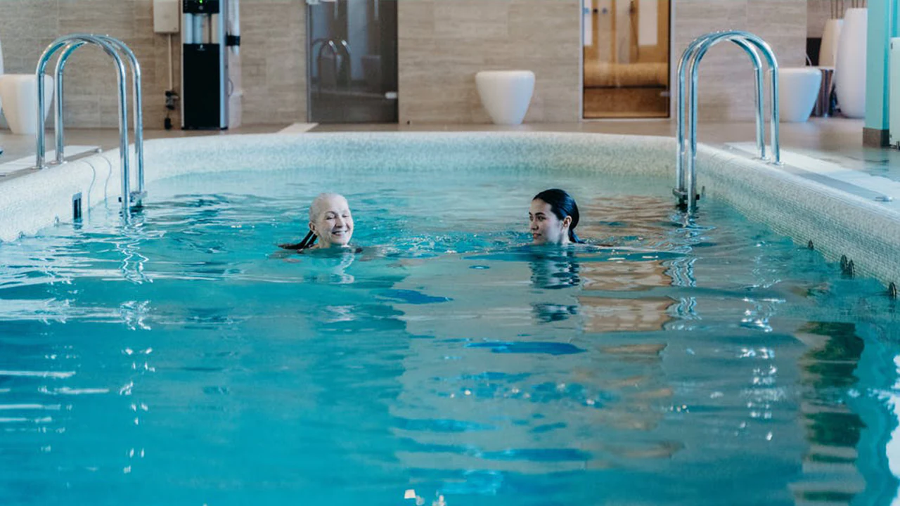 Image of two people swimming in a pool.