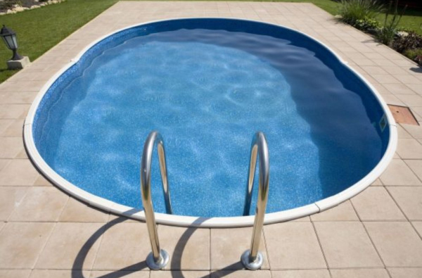 A blu-line oval swimming pool with a swimming pool ladder.