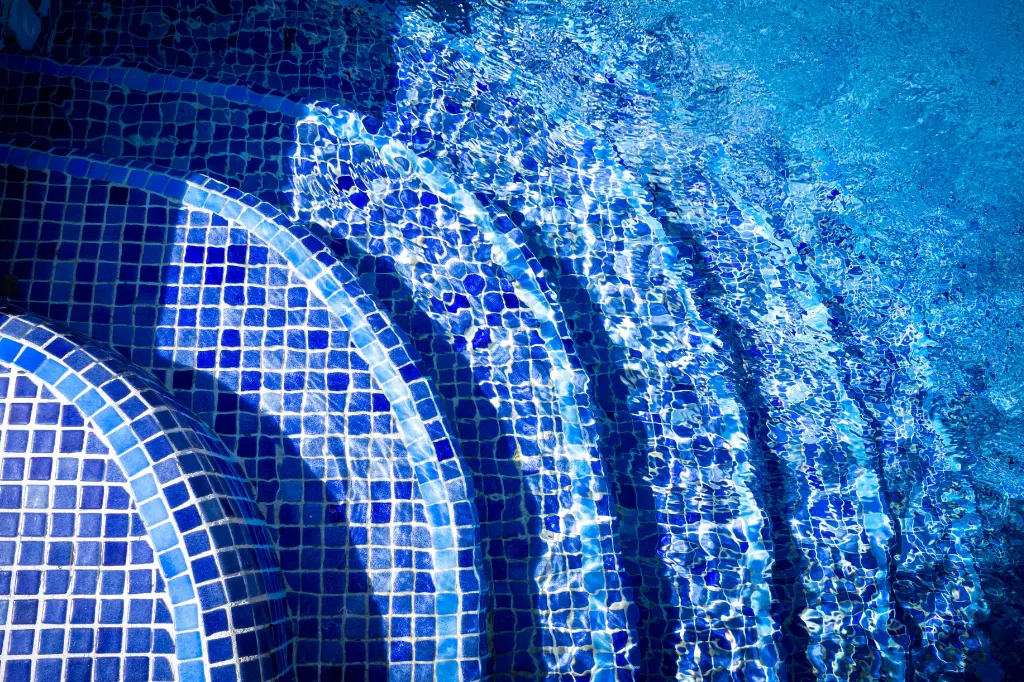 Blue tiled pool steps and water, for easy pool access.